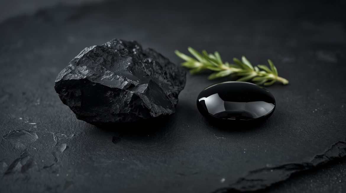 Гагат — чёрный камень-оберег с магическими защитными свойствами, полированный чёрный янтарь в руке